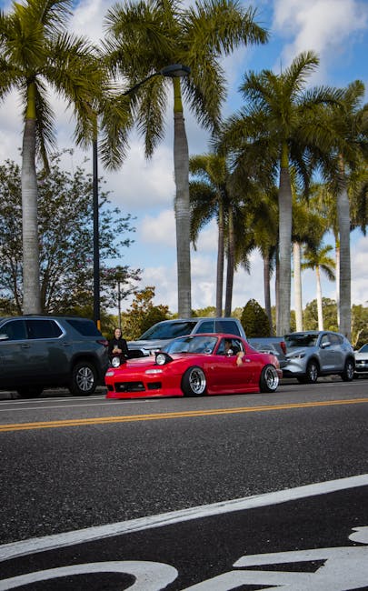 Red sports car under palm trees